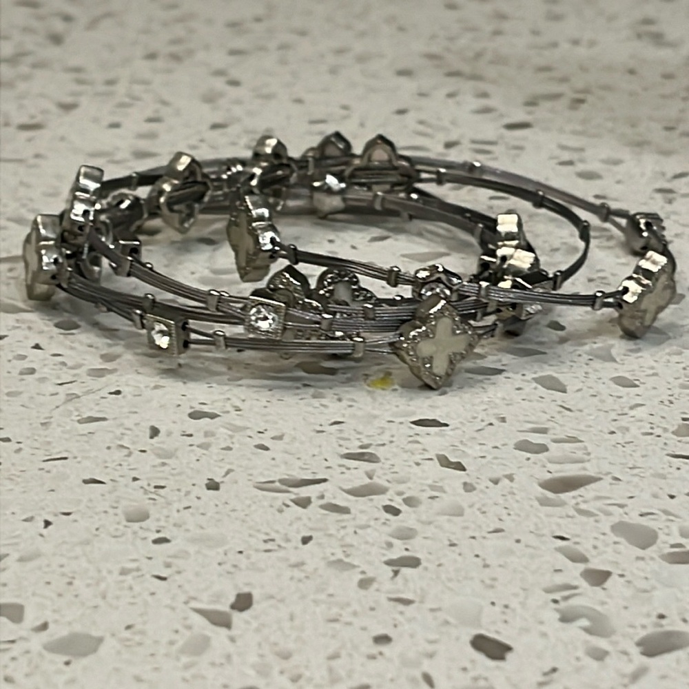 Set of six silver colored bangles with white flowers and clear crystals